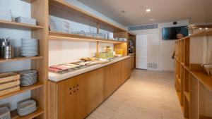 a kitchen with a counter with plates and dishes at Hotel Rosamar - Emar Hotels in Es Pujols