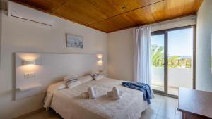 a bedroom with a bed with a view of the ocean at Hotel Rosamar - Emar Hotels in Es Pujols
