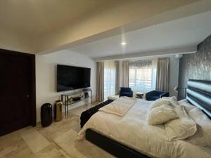 a bedroom with a large bed and a flat screen tv at Villa Casa Blanca in Las Palmas +24 photos