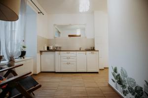 a kitchen with white cabinets and a mirror at Off Piotrkowska Spot in Łódź