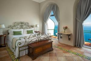 a bedroom with a bed and a large window at Hotel Caesar Augustus in Anacapri