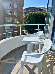 two white chairs and a table on a balcony at STELA in Nesebar