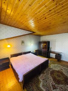 a bedroom with a large bed with a wooden ceiling at Guest House Raisa in Dilijan