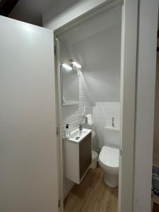 a white bathroom with a sink and a toilet at Casa Nel in Abándames