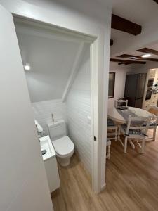 a bathroom with a toilet and a dining room at Casa Nel in Abándames