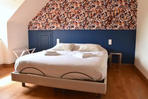 a bedroom with a large bed with a blue wall at Gîte La Mancellière - Maison familiale 12pers, grand jardin, jeux & pétanque - Pleine nature 