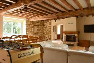 a living room with a foosball table in the middle of a room at Gîte La Mancellière - Maison familiale 12pers, grand jardin, jeux & pétanque - Pleine nature 