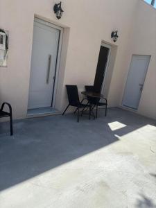 a room with two chairs and a table and two doors at Sunset Realty Studios in Kinion