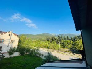 a view of a road with a house and mountains at Guest House Raisa in Dilijan