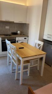 a wooden table and chairs in a kitchen at Sunset Realty Studios in Kinion