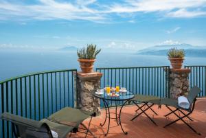 a balcony with a table and chairs and the ocean at Hotel Caesar Augustus in Anacapri