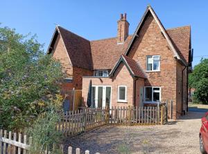 an old brick house with a wooden fence at Flo's Cottage self-catering in Newark-on-Trent