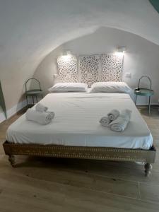 a bedroom with a large bed with towels on it at Casa mia MadamA in Gaeta