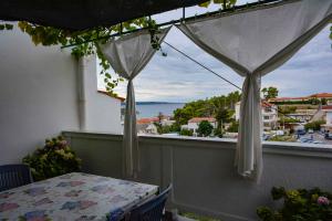 balkon ze stołem i widokiem na ocean w obiekcie Apartment in Banjol - Insel Rab 26609 w mieście Banjol