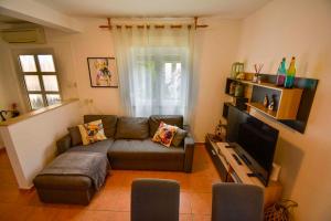 salon z kanapą i telewizorem z płaskim ekranem w obiekcie Apartment in Banjol - Insel Rab 26609 w mieście Banjol