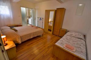 niewielka sypialnia z 2 łóżkami i lustrem w obiekcie Apartment in Banjol - Insel Rab 26609 w mieście Banjol