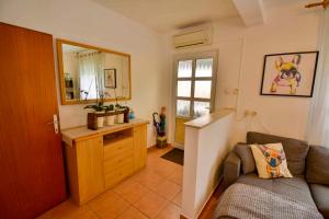salon z kanapą i lustrem w obiekcie Apartment in Banjol - Insel Rab 26609 w mieście Banjol