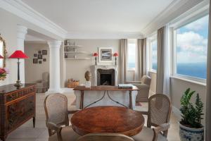a living room with a table and a fireplace at Hotel Caesar Augustus in Anacapri