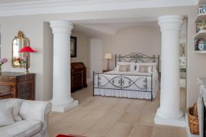 a bedroom with a bed with white columns at Hotel Caesar Augustus in Anacapri
