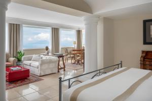 a bedroom with a bed and a living room at Hotel Caesar Augustus in Anacapri