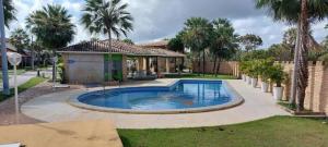 una piscina in un cortile con palme di Lençóis Park Residence Flat 106 Caburé a Barreirinhas