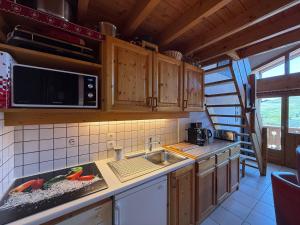 a kitchen with a sink and a microwave at Les Saisies Appartement 3 Pièces 8 Pers. avec 2 SDB et Garage - FR-1-293-275 in Hauteluce +11 photos