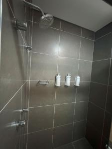 a bathroom with a shower with three rolls of toiletries at Matiz Multi Suites in Duque de Caxias