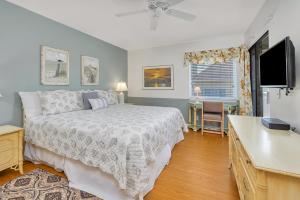a bedroom with a bed and a desk and a television at Shipwatch #307 in Saint Simons Island