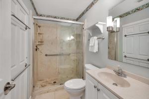 a bathroom with a shower and a toilet and a sink at Shipwatch #307 in Saint Simons Island +23 photos