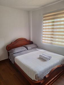 a bed with a wooden headboard in a bedroom at Apartamento Completo Socorro Santander 3 Habitaciones in Socorro +8 photos