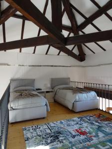 a bedroom with two beds and a rug on the floor at Mia Experience Lake Como in San Fermo della Battaglia