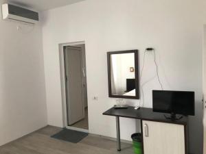 una stanza con uno specchio e una scrivania con una televisione di Babylonia Resort a Costinesti