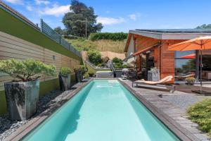 a swimming pool in the backyard of a house at Exquisite 5-Bedroom Villa in Arzier for Families by GuestLee in Arzier