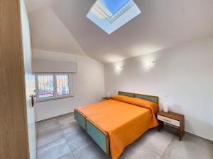 a bedroom with a bed and a skylight at Appartamento Mare e Relax in Bellaria-Igea Marina