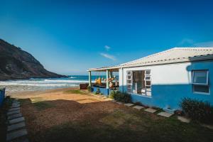 a blue and white house with a view of the ocean at Silver Spray Beach Accommodation in Victoria Bay +32 photos