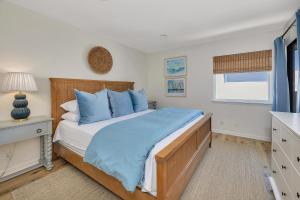 a bedroom with a large bed with blue pillows at Shipwatch #311 in Saint Simons Island +27 photos