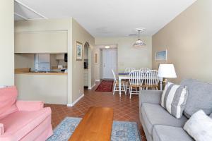 a living room with a couch and a table at Shipwatch #312 in East End