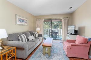 a living room with a couch and two chairs and a tv at Shipwatch #312 in East End