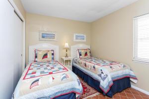 a bedroom with two beds and a window at Shipwatch #312 in East End +30 photos