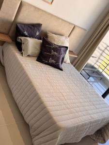 a bed with pillows on it in a room at Suit Chalet Santiago in Santiago del Estero