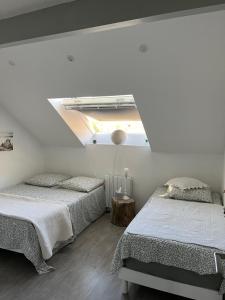 2 Betten in einem weißen Zimmer mit einer Decke in der Unterkunft Superbe T3 A DOUSSARD in Doussard