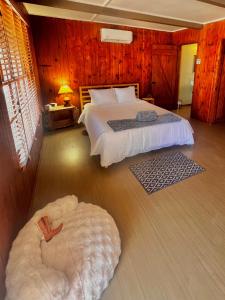a bedroom with a large bed and a large ottoman at Room 5 - Downtown Joshua Tree Motel - Pet Friendly - Walk to Shops & Visitor Center, Minutes to Park Entrance in Joshua Tree +8 photos