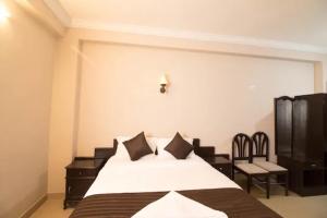 una camera da letto con un letto grande e una sedia di Mount shelter -city centre budget room a Munnar
