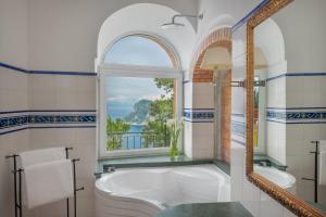a bathroom with a tub and a window at Hotel Caesar Augustus in Anacapri