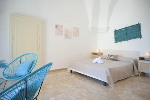 a bedroom with a bed and a blue chair at A L Tourist House - La Corte Bianca - La Torre Blu in Carovigno