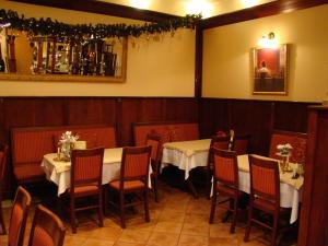 a dining room with two tables and chairs and a mirror at Hotel Centras in Šakiai