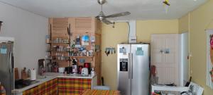 a kitchen with a refrigerator and a counter top at Cocon Alizé - Studio cozy, Port-Louis centre, plage à 10 min à pied in Port-Louis