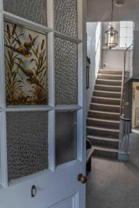 Una puerta a un pasillo con una escalera y una caja de escalera. en 2 Bath House, en Ilfracombe