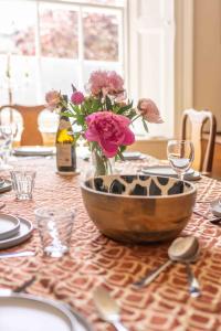 una mesa con un jarrón de flores sobre una mesa en 2 Bath House, en Ilfracombe 61 fotos más