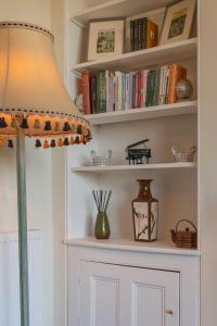 Una habitación con un estante con libros y una lámpara. en 2 Bath House, en Ilfracombe